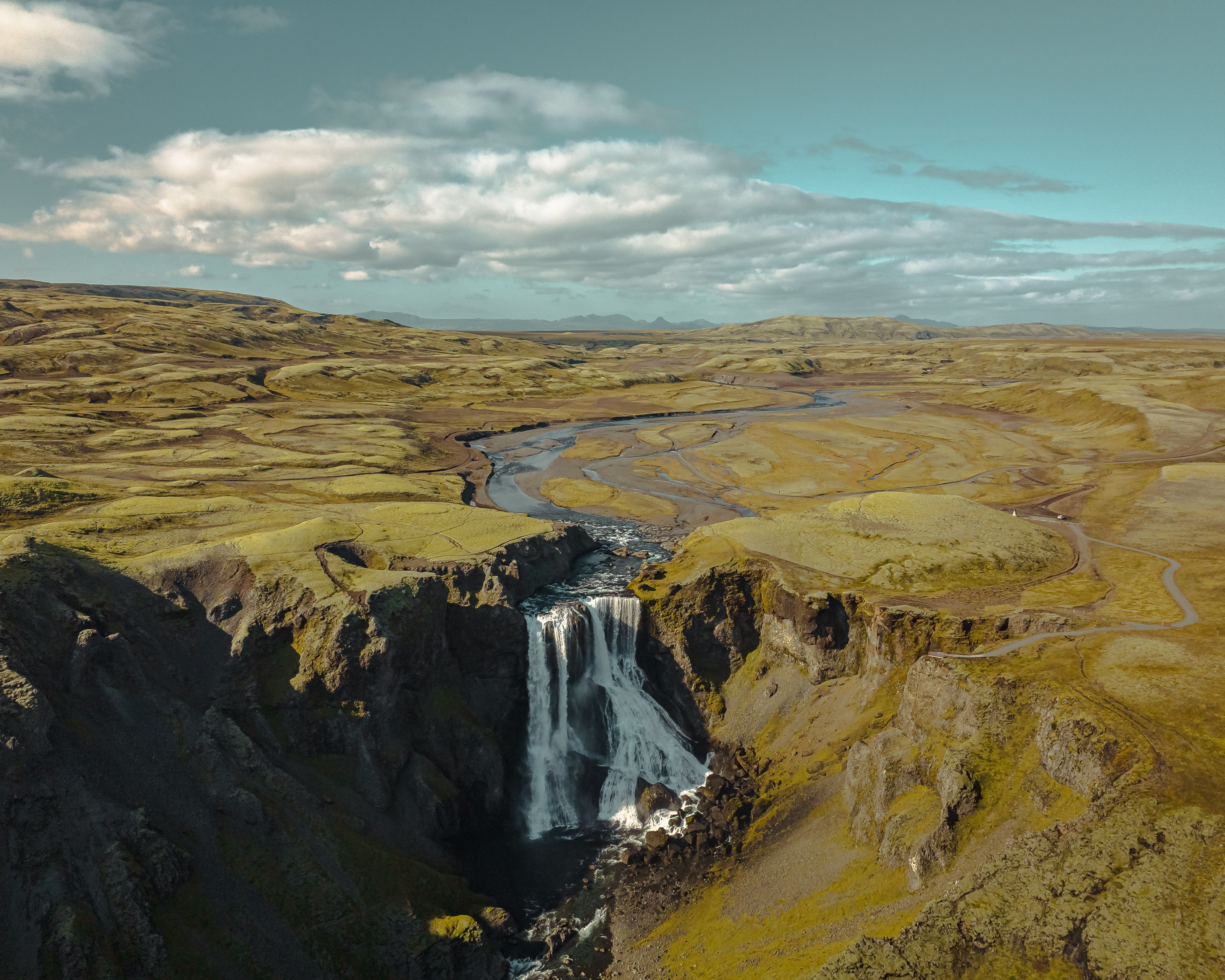 Modified 4x4 navigating the F206 river crossing with the Fagrifoss waterfall, South Iceland.