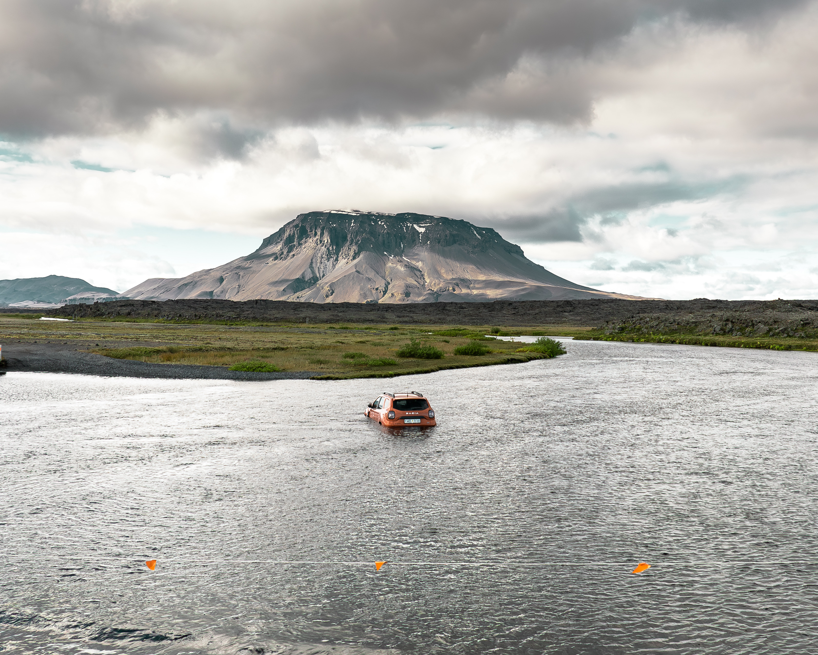 A Dacia Duster submerged and stuck in an Icelandic highland river after a failed crossing attempt on an F-road.