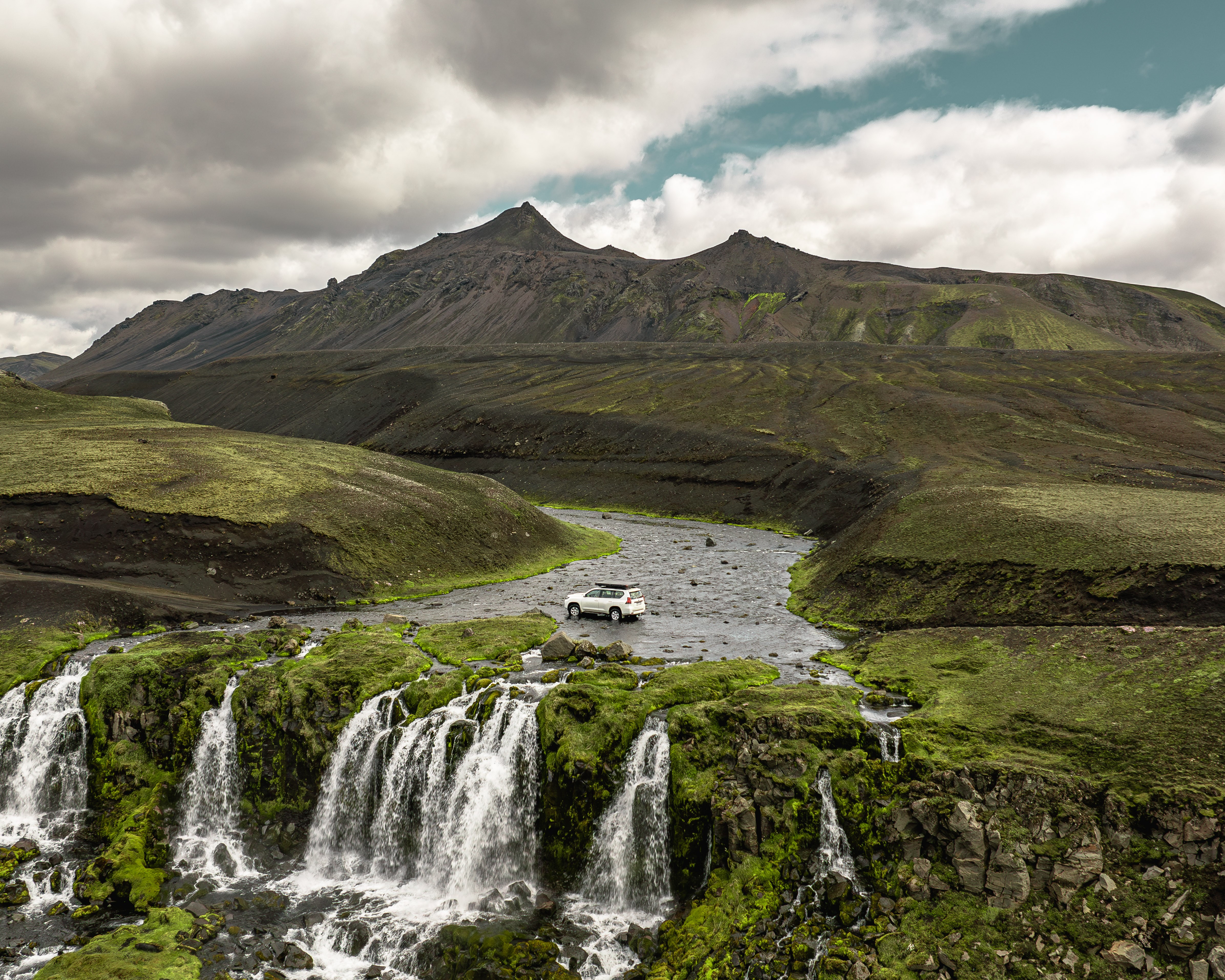Toyota Land Cruiser 150 with rooftop tent performing a river crossing on an F-road in the Iceland Highlands.