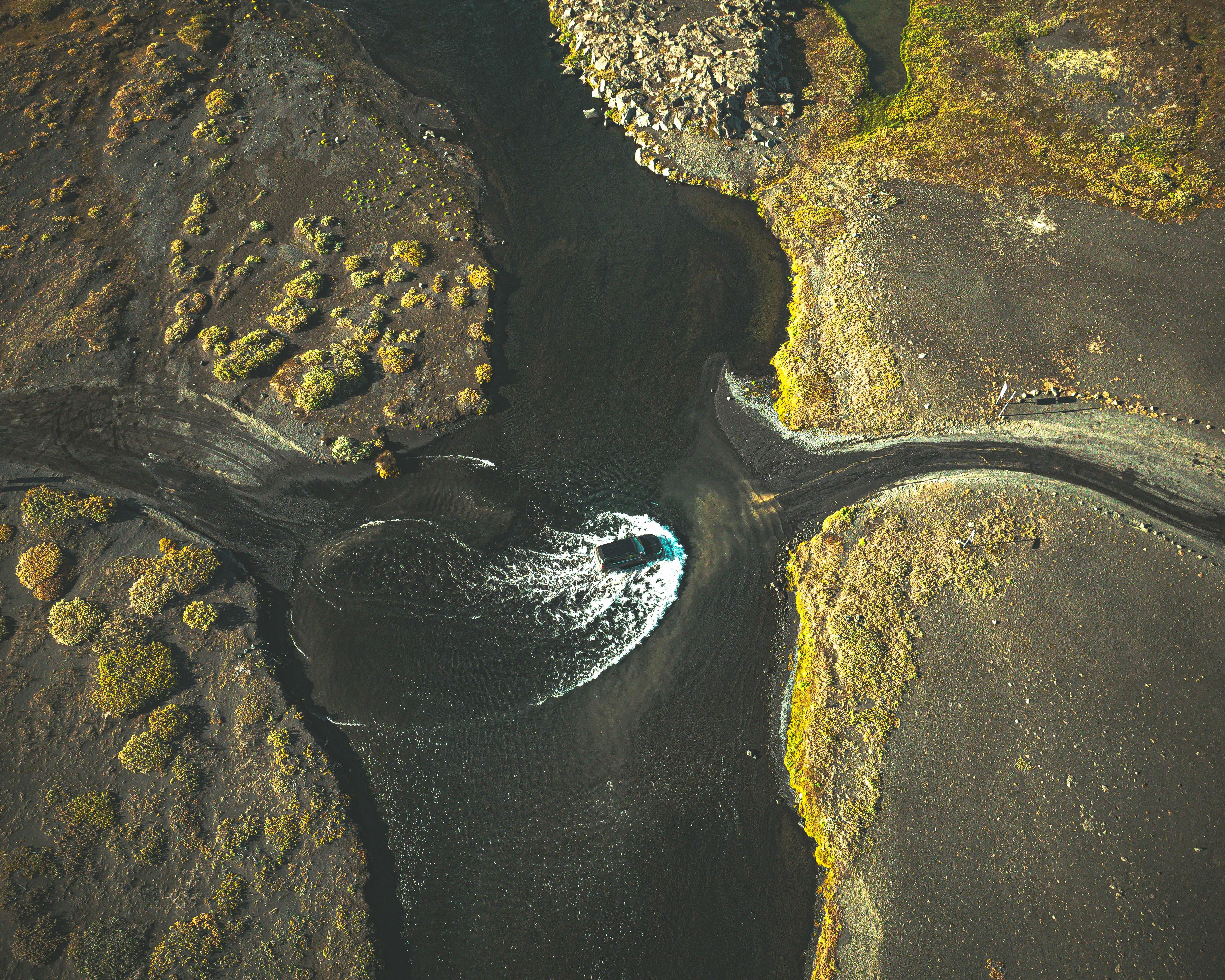 Aerial drone view of a Toyota Land Cruiser crossing a glacial river on an F-road in the Iceland Highlands.